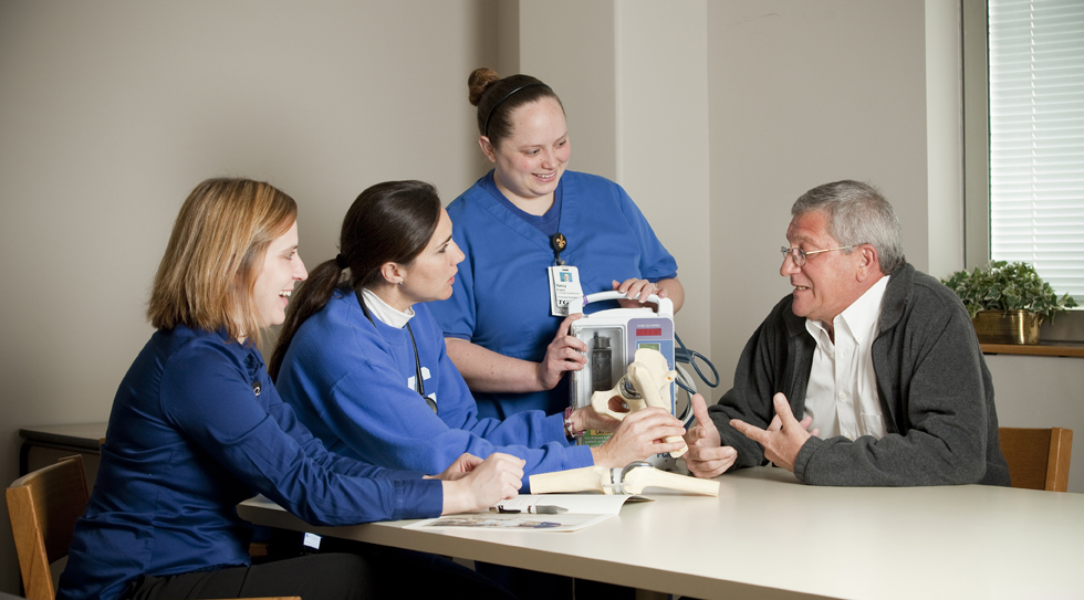 nurses talking to senior patient